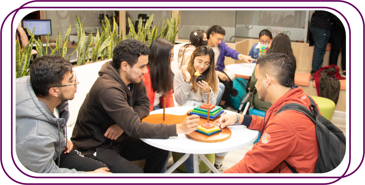 Jovenes interactuando en una mesa redonda en un espacio de trabajo dinámico