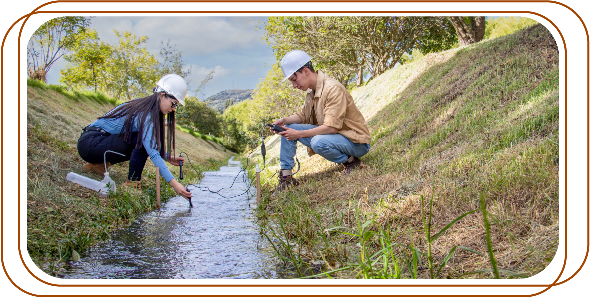 dos personas usando equipos de medición en un canal de agua al aire libre. Ambos llevan cascos de protección.