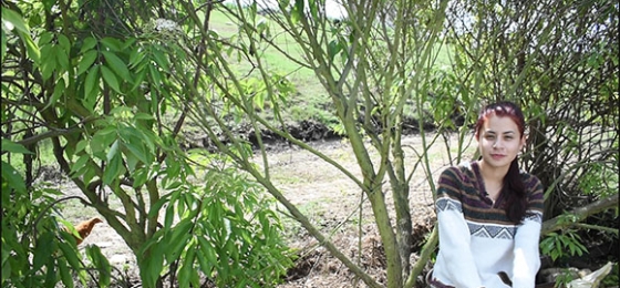 Mujer joven frente a un árbol