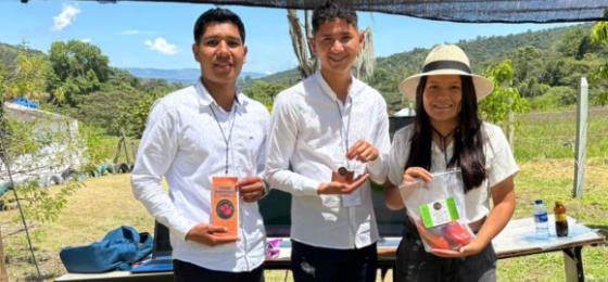 Estudiantes exponen sus productos durante una feria al aire libre.